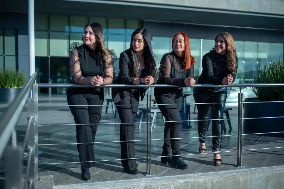 Confident women in business attire standing outdoors, embracing teamwork and leadership.