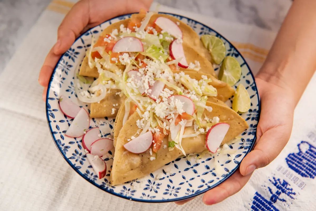 Close-up of delicious Mexican tacos with fresh garnishes, perfect for food lovers.